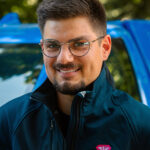 Portrait de Jules, devant son pick-up d'intervention rose et bleu. Déboucheur franchisé de la Compagnie des Déboucheurs sur le département de la Mayenne