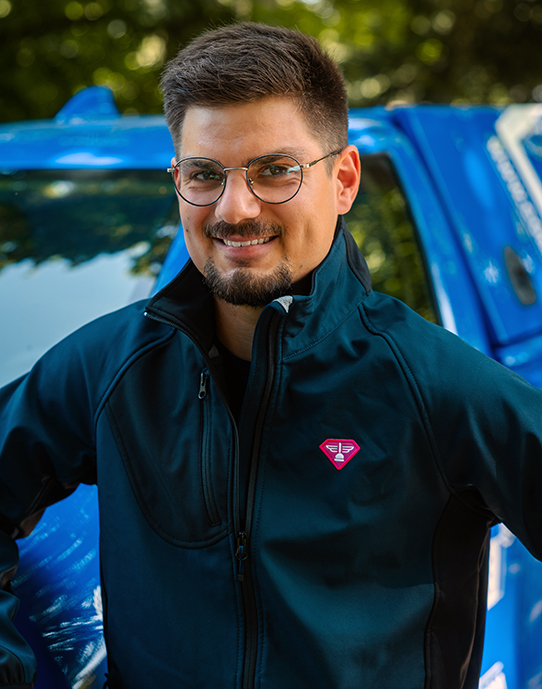 Portrait-de-Jules_deboucheur-Mayenne Portrait de Jules, devant son pick-up d'intervention rose et bleu. Déboucheur franchisé de la Compagnie des Déboucheurs sur le département de la Mayenne. Prêt pour toute intervention de débouchage de canalisation !